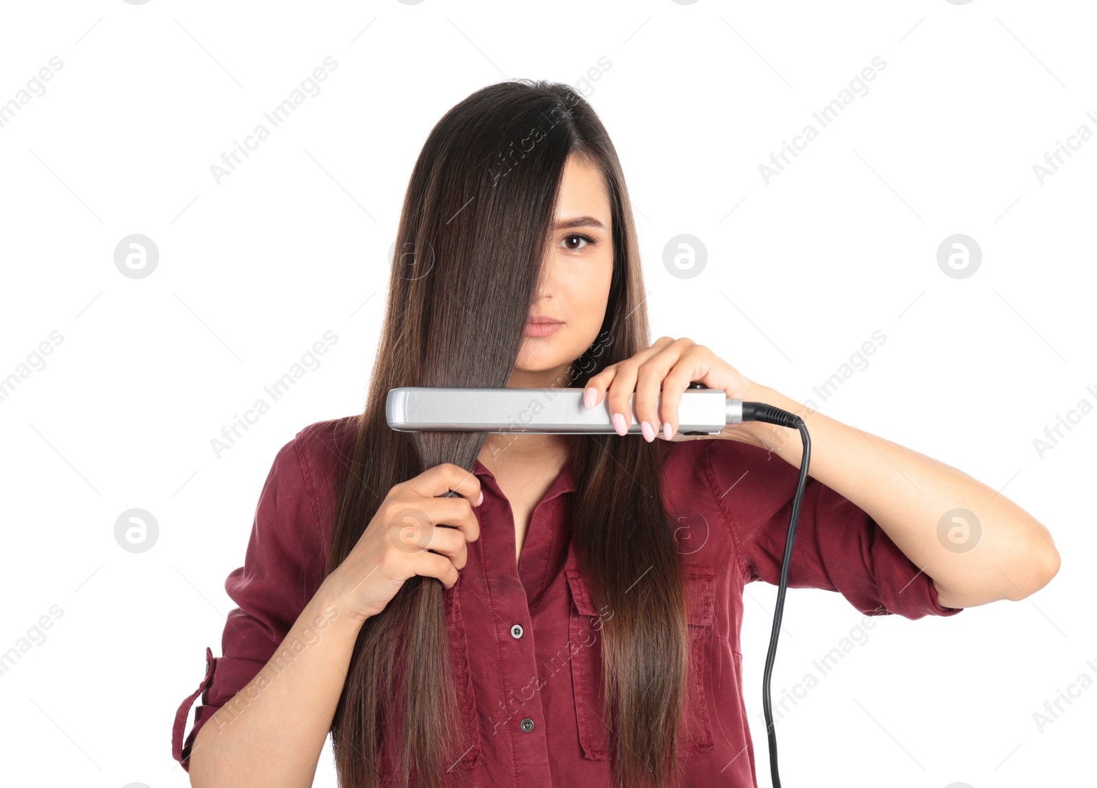 Photo of Young woman using hair iron on white background