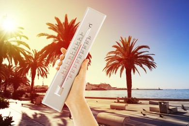 Image of Woman holding thermometer on beach in summer, closeup