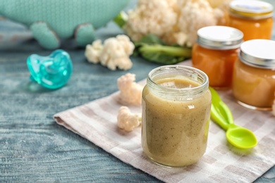 Photo of Jar with healthy baby food on table