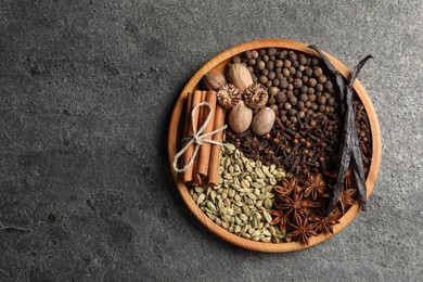 Different spices and nuts on gray textured table, top view. Space for text