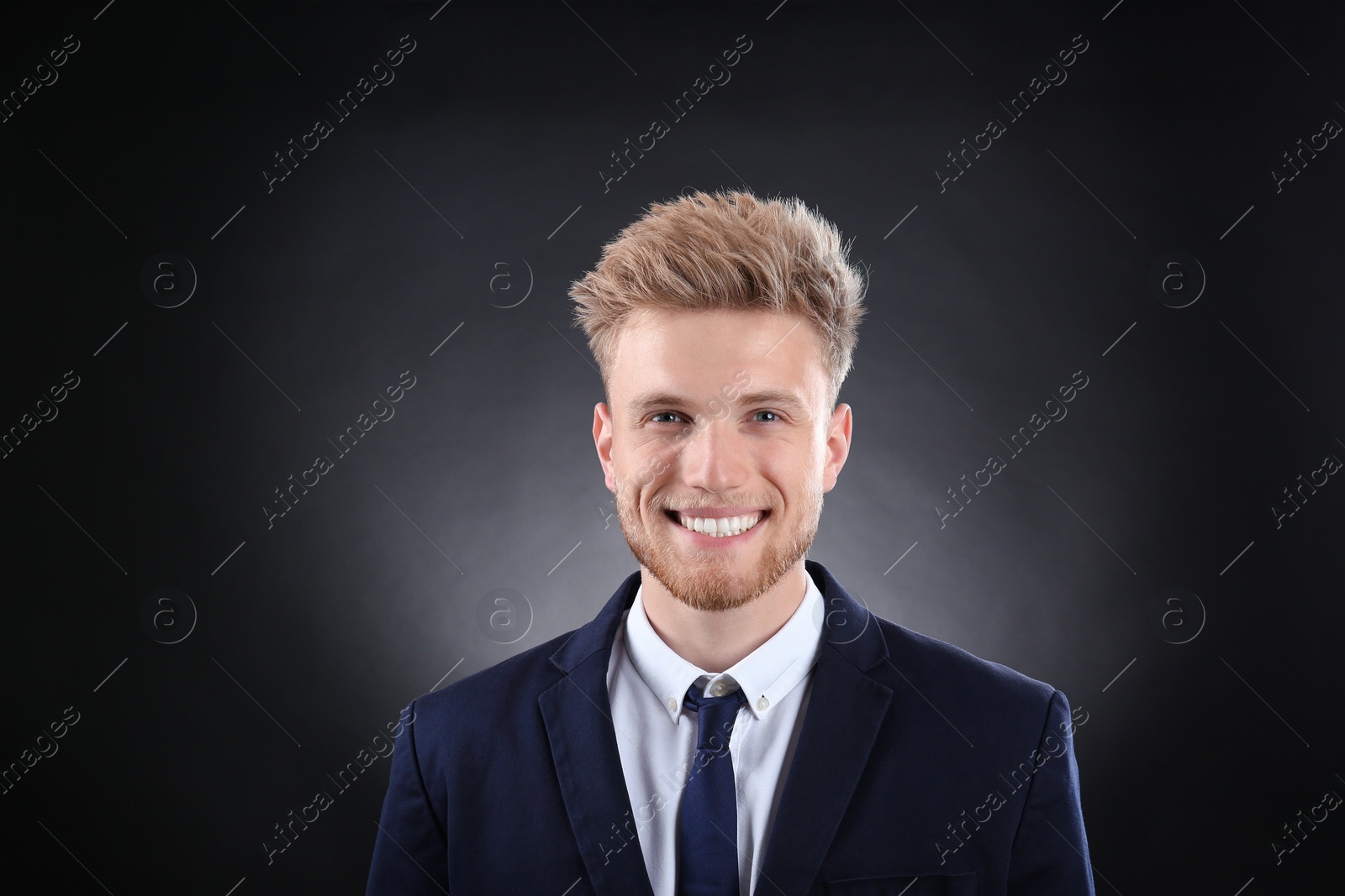 Photo of Portrait of handsome young businessman on dark background