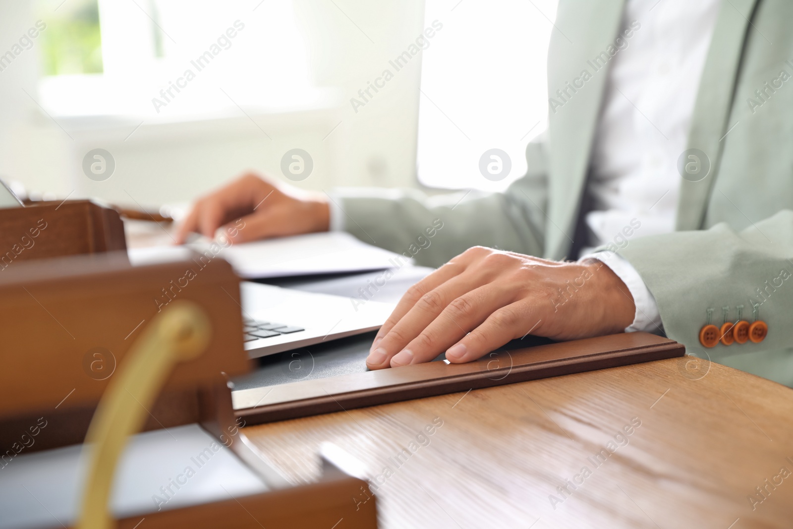 Photo of Male notary working with laptop at table in office, closeup