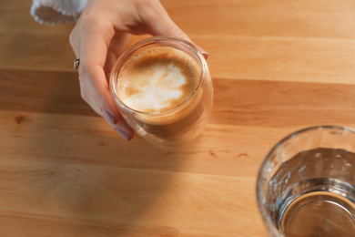 Photo of Woman with aromatic coffee at table in cafe, above view