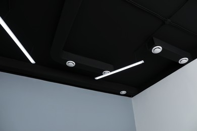 Black ceiling with modern lighting in office