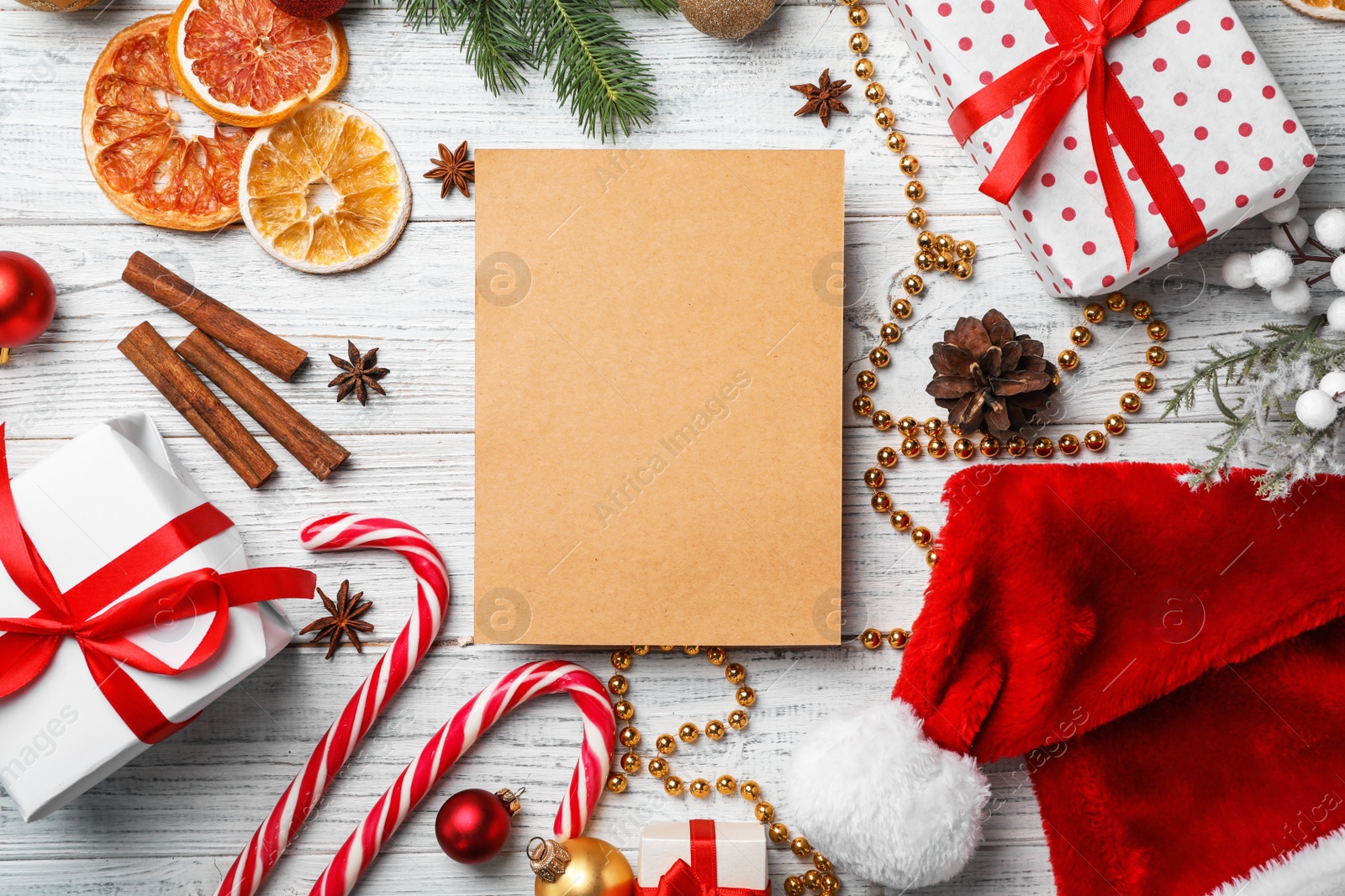 Photo of Flat lay composition with paper and Christmas decor on wooden background. Letter for Santa Claus