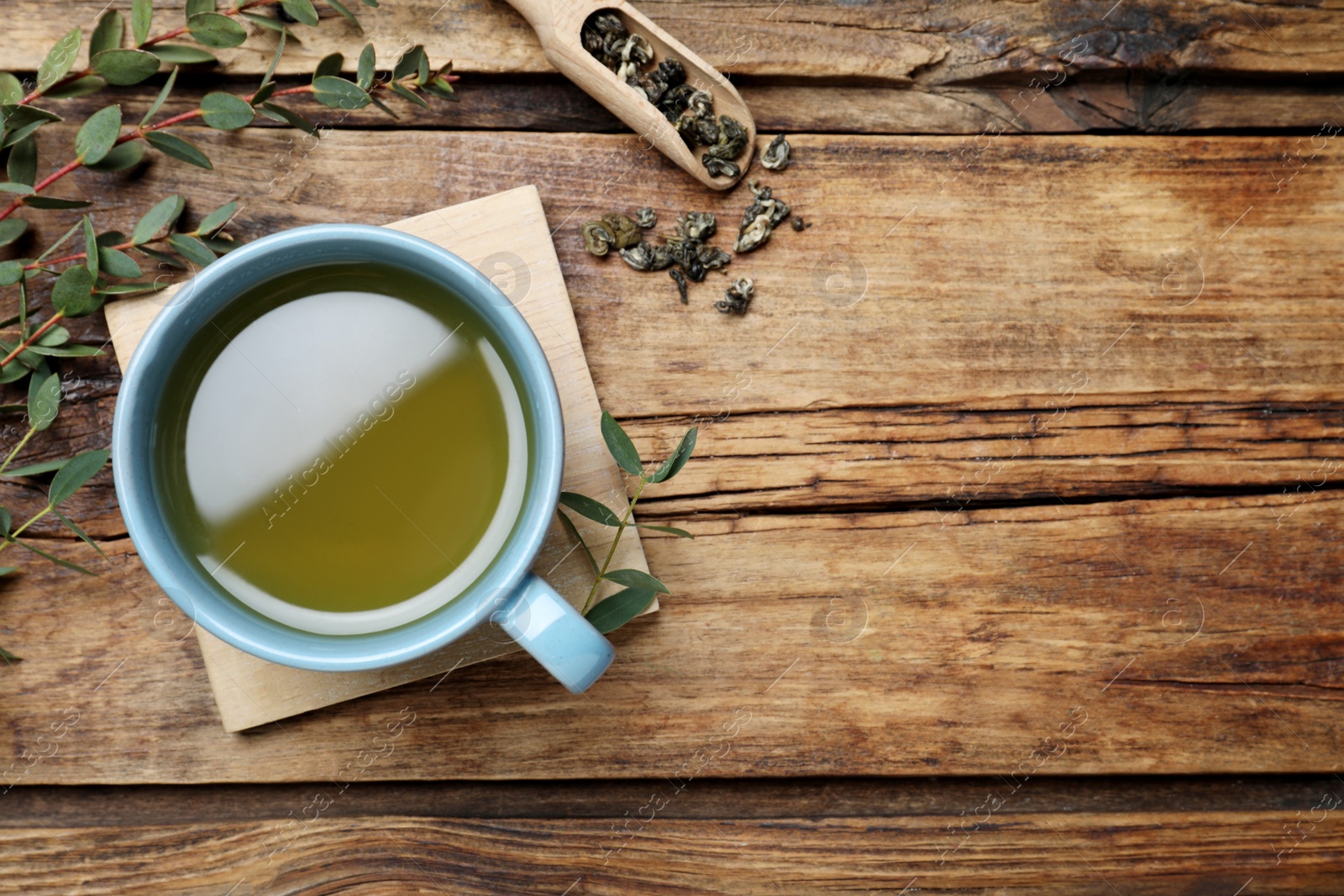 Photo of Flat lay composition with eucalyptus tea on wooden table. Space for text