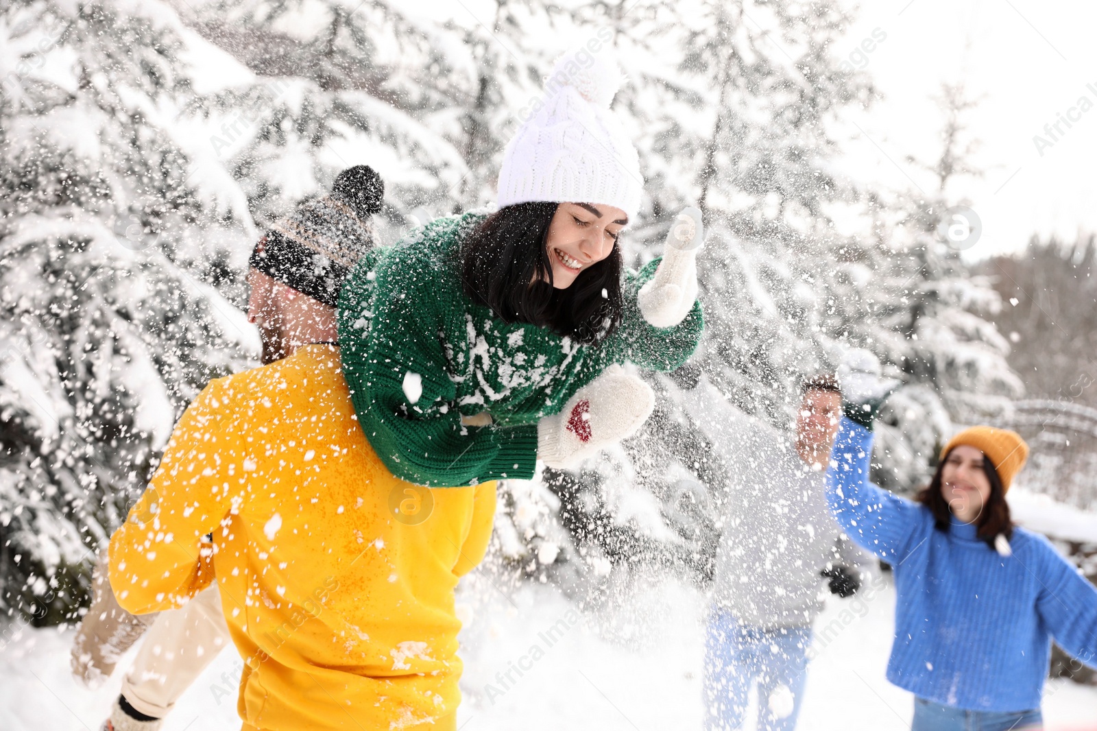 Photo of Group of friends playing snowballs outdoors. Winter vacation