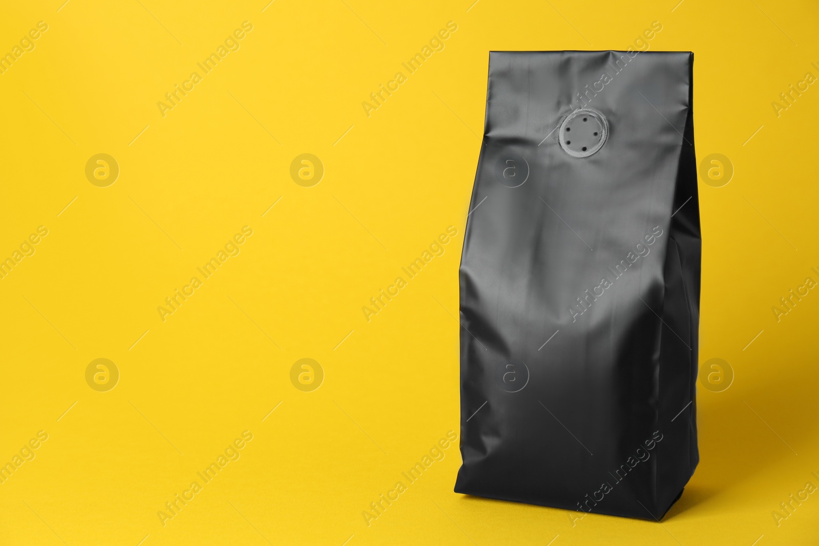 Photo of One blank foil package on yellow background. Space for text