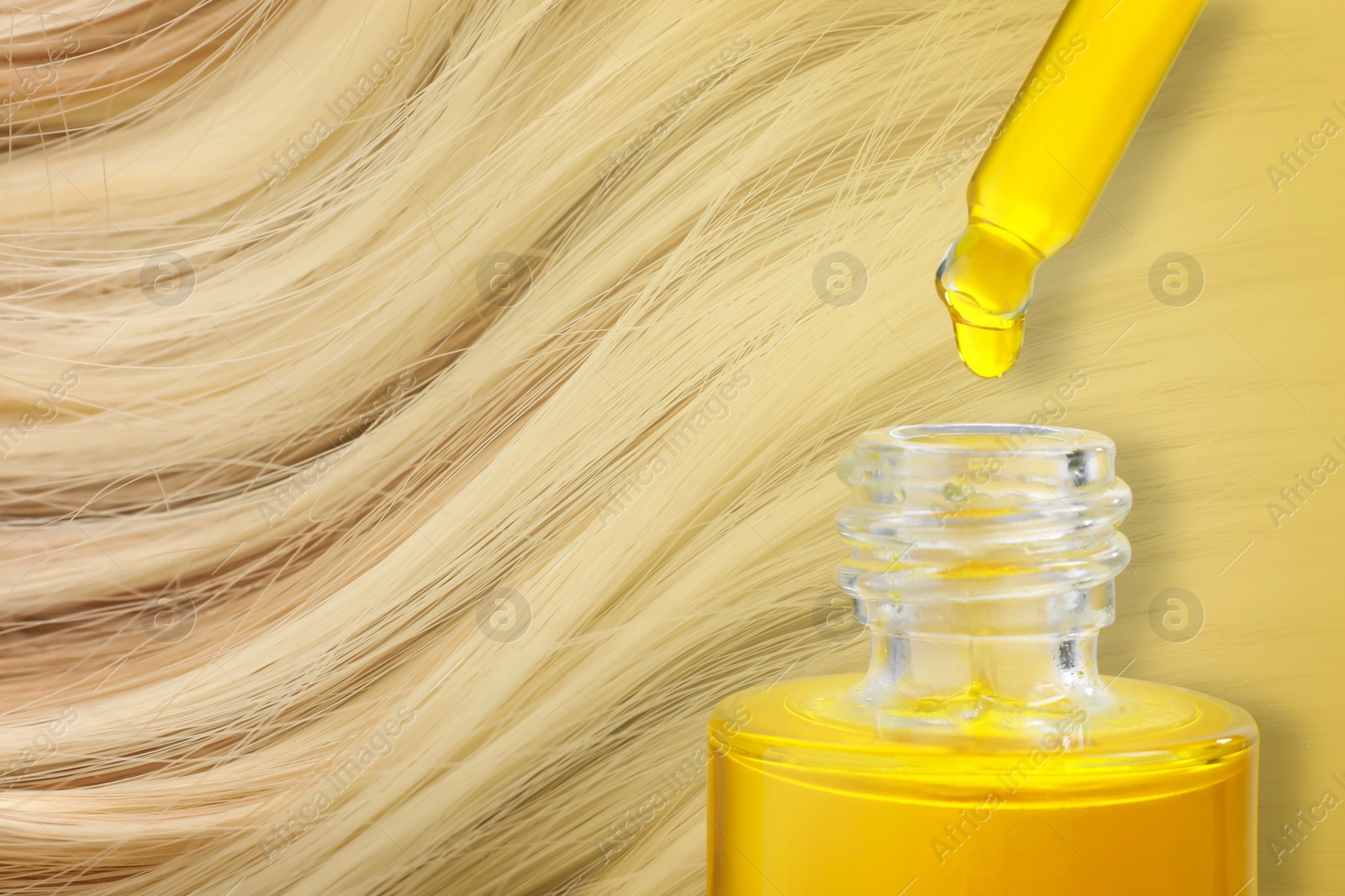 Image of Dripping serum from pipette into bottle against beautiful blonde hair