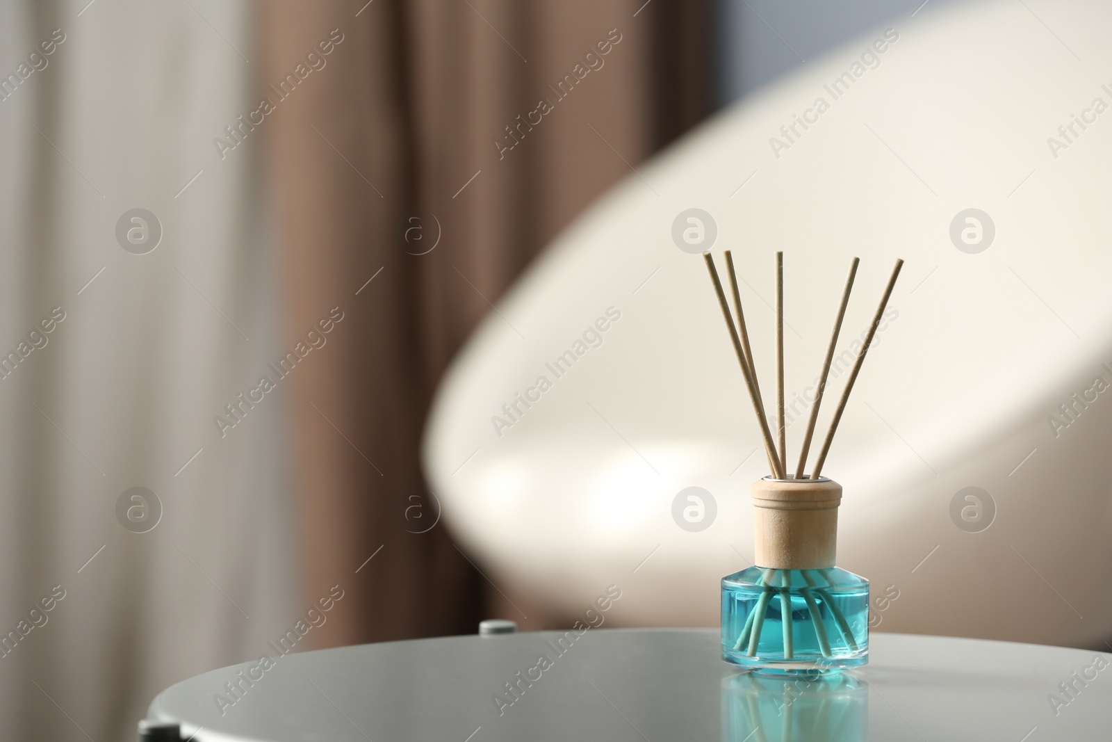 Photo of Reed air freshener on table indoors, space for text