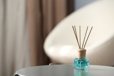 Reed air freshener on table indoors, space for text