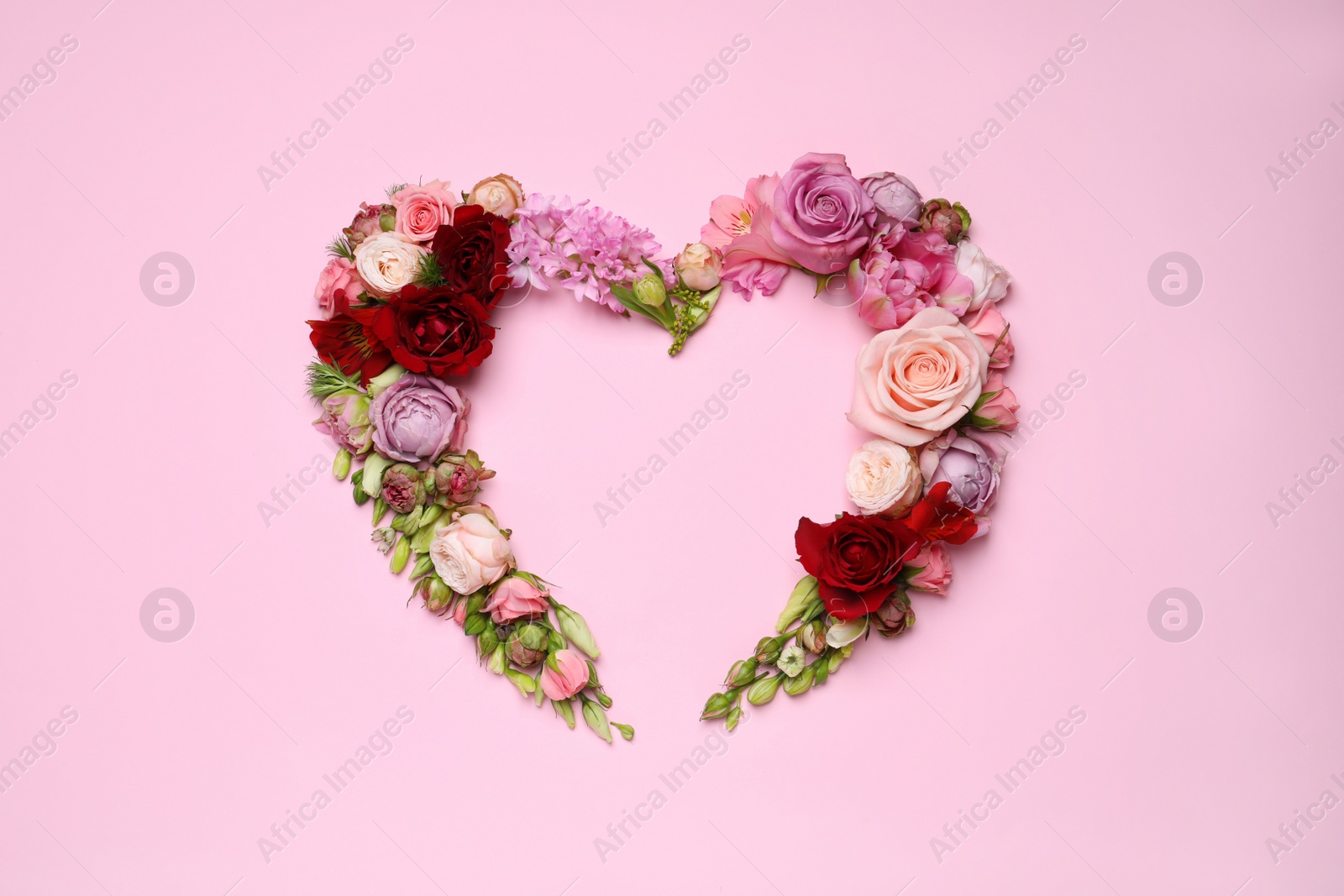 Photo of Beautiful heart shaped floral composition on pink background, flat lay