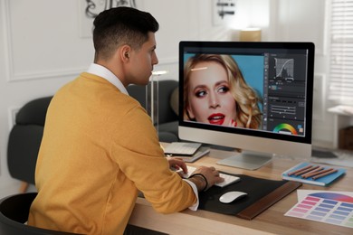 Professional retoucher working on computer in office