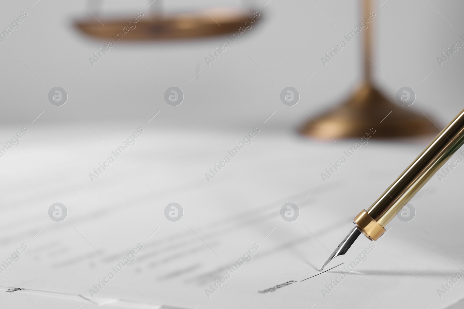 Photo of Signing document with fountain pen at table, closeup and space for text. Notary contract