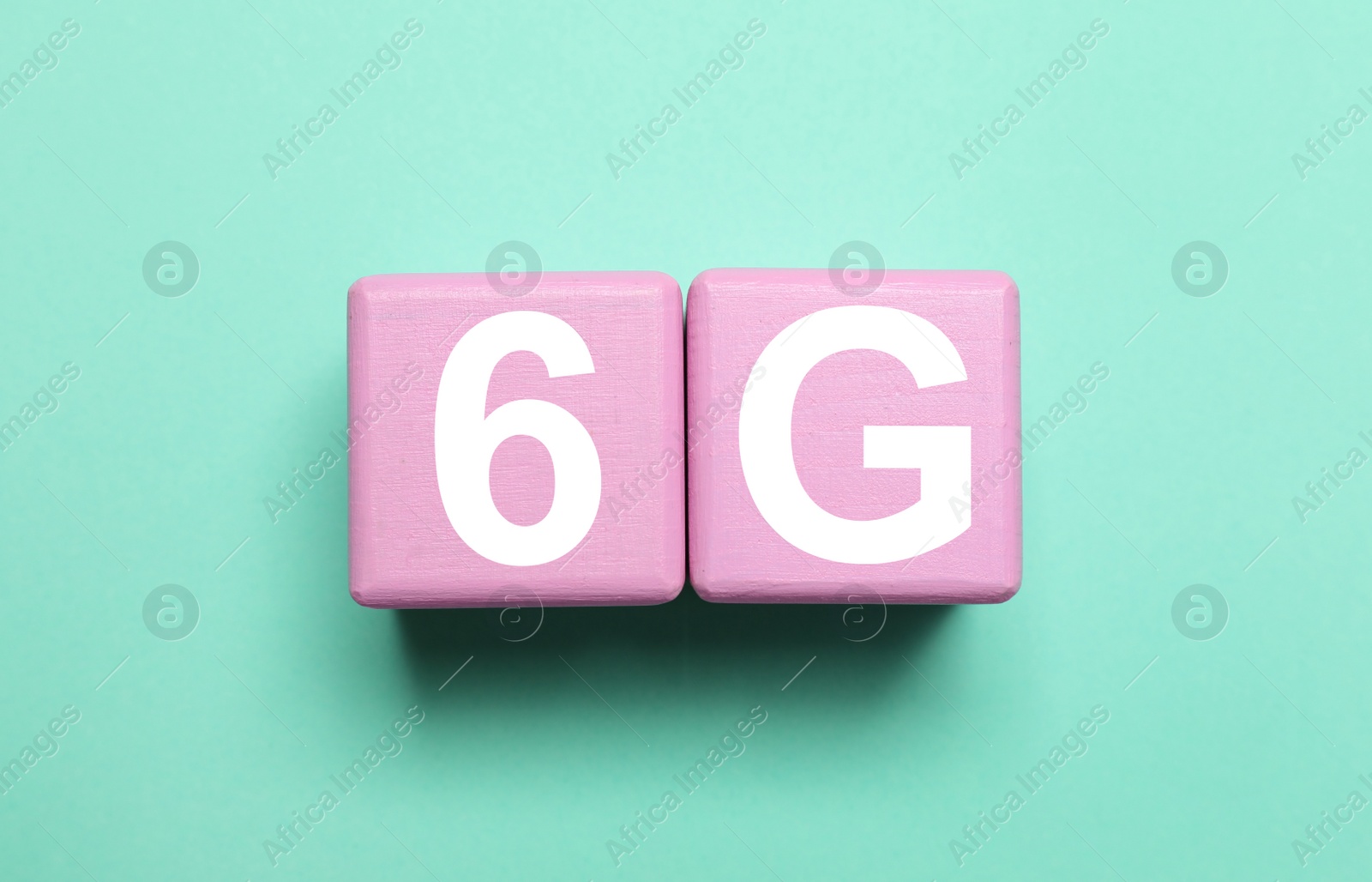 Photo of Internet concept. Color wooden cubes with phrase 6G on turquoise background, flat lay