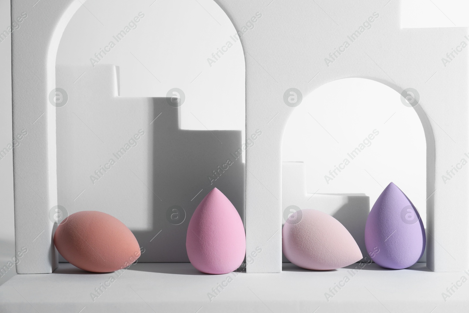 Photo of Stylish presentation of makeup sponges on white background