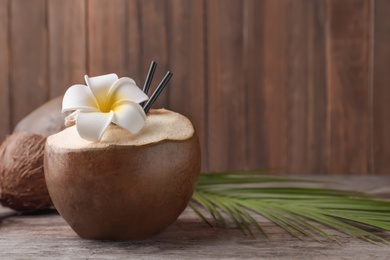Photo of Fresh green coconut on table against wooden background
