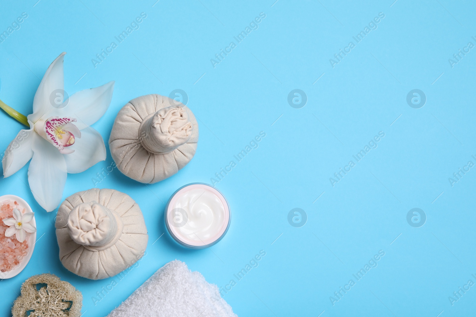 Photo of Flat lay composition with spa products and beautiful flower on light blue background. Space for text