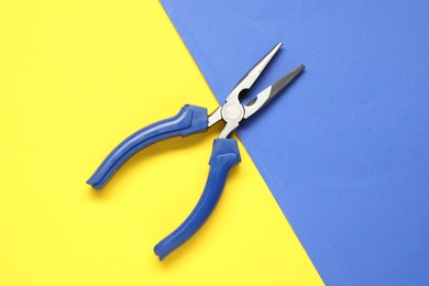 Needle nose pliers on color background, top view