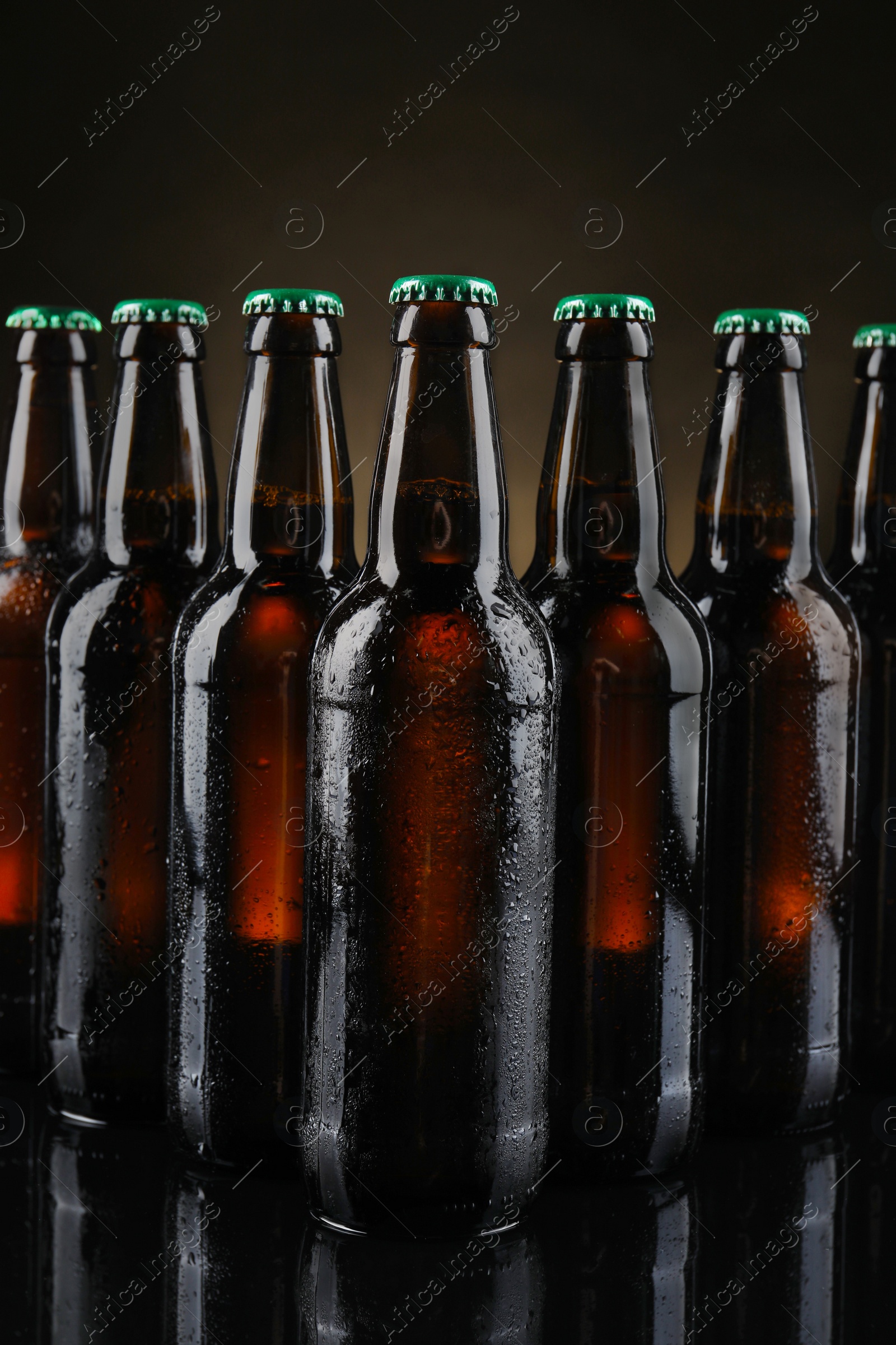 Photo of Many bottles of beer on dark background, closeup