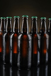 Many bottles of beer on dark background, closeup
