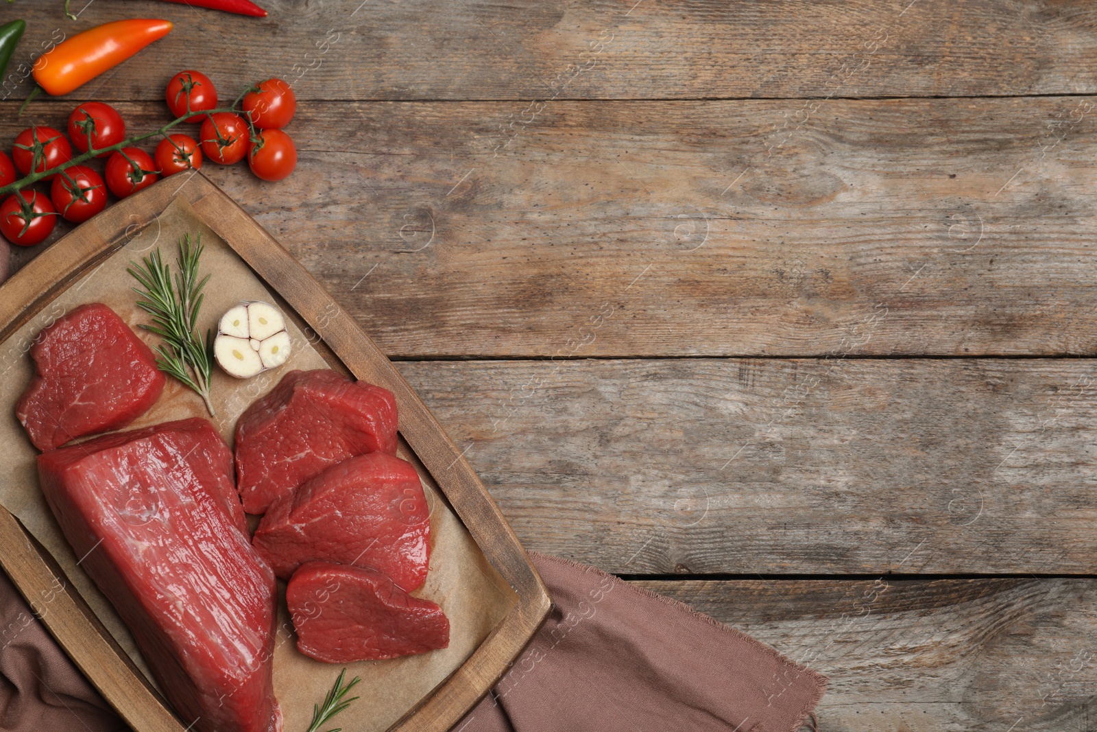 Photo of Flat lay composition with fresh raw meat, products and space for text on wooden background