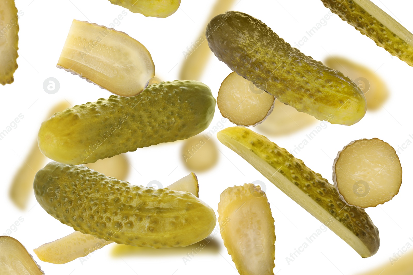 Image of Tasty pickled cucumbers falling on white background