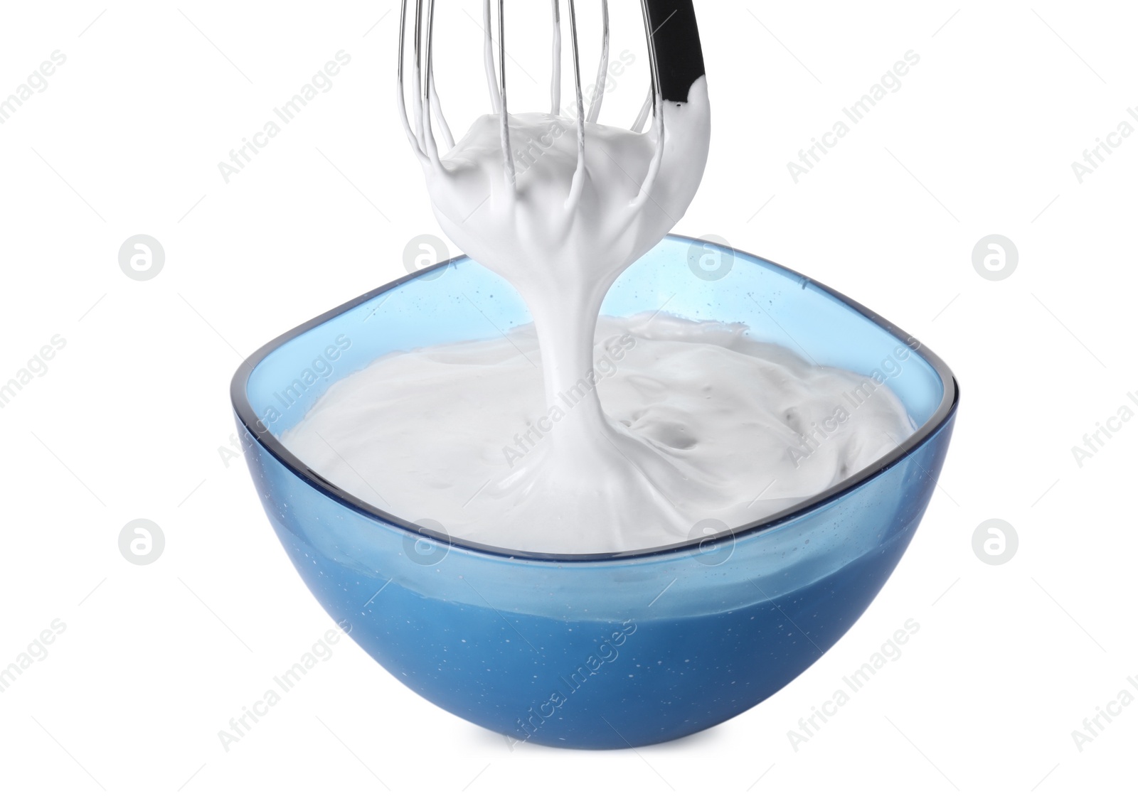 Photo of Whipped cream flowing from whisk into bowl isolated on white