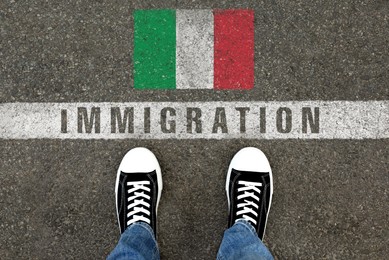 Image of Immigration. Man standing on asphalt near flag of Italy, top view