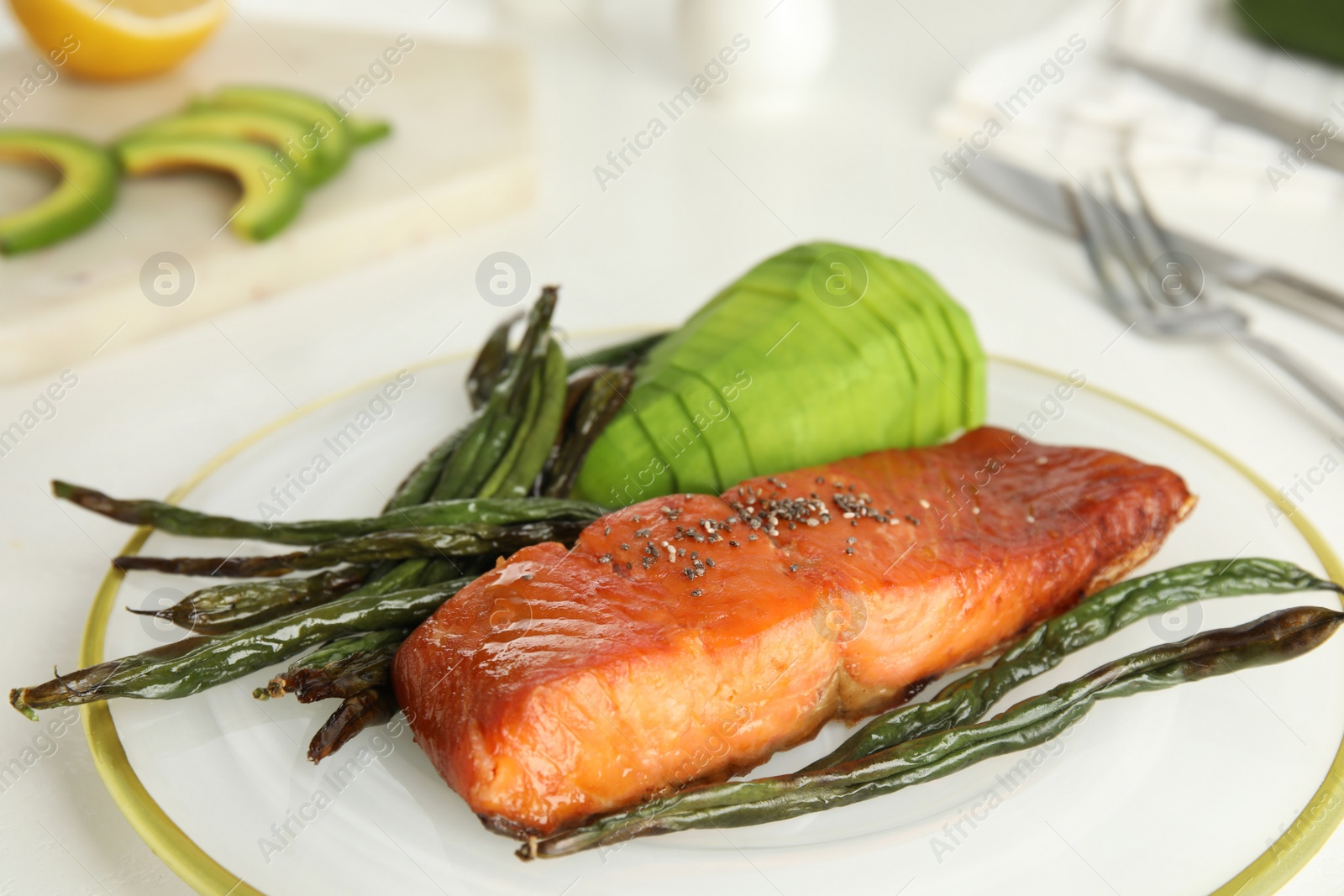 Photo of Tasty cooked salmon and vegetables served on white table, closeup. Healthy meals from air fryer