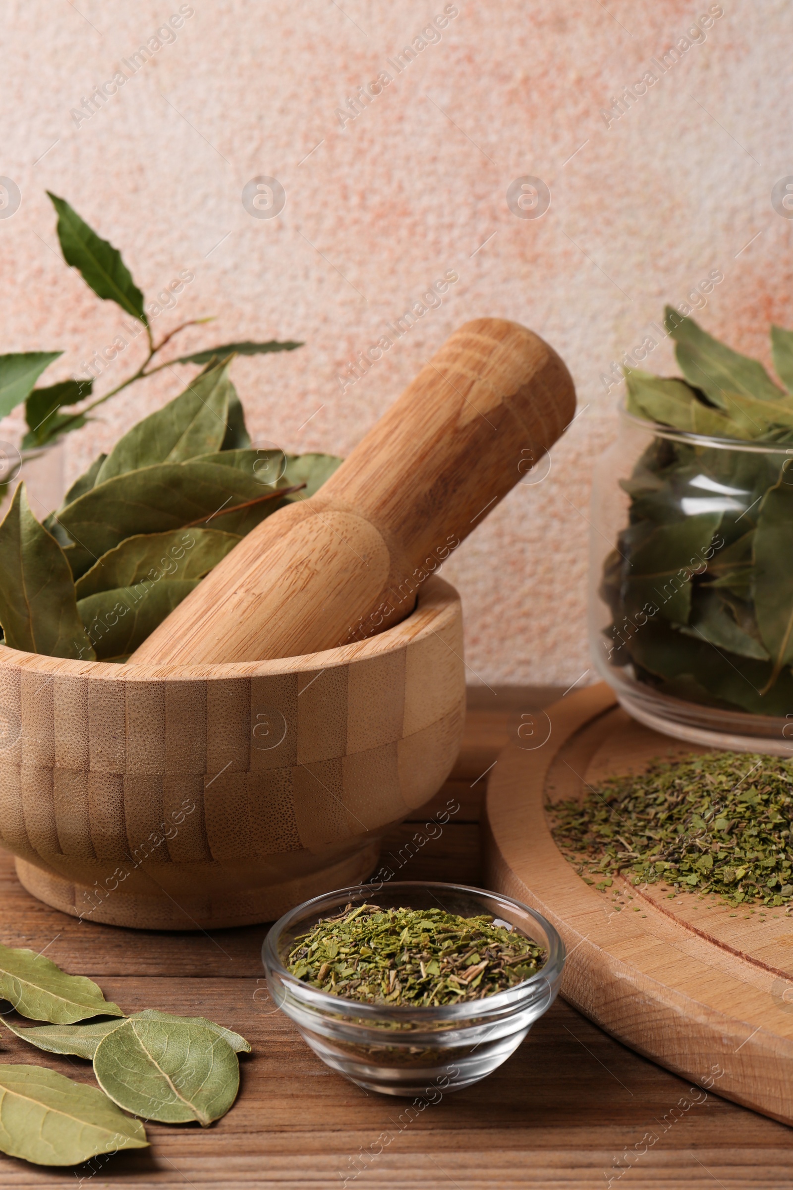 Photo of Whole and ground aromatic bay leaves on wooden table