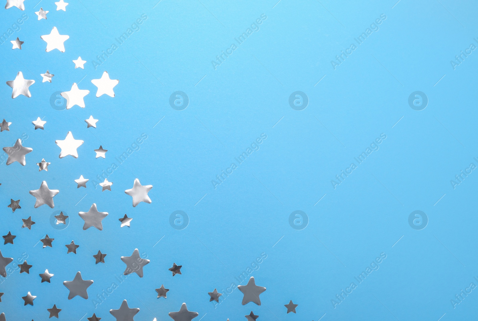 Photo of Confetti stars with space for text on blue background, top view. Christmas celebration