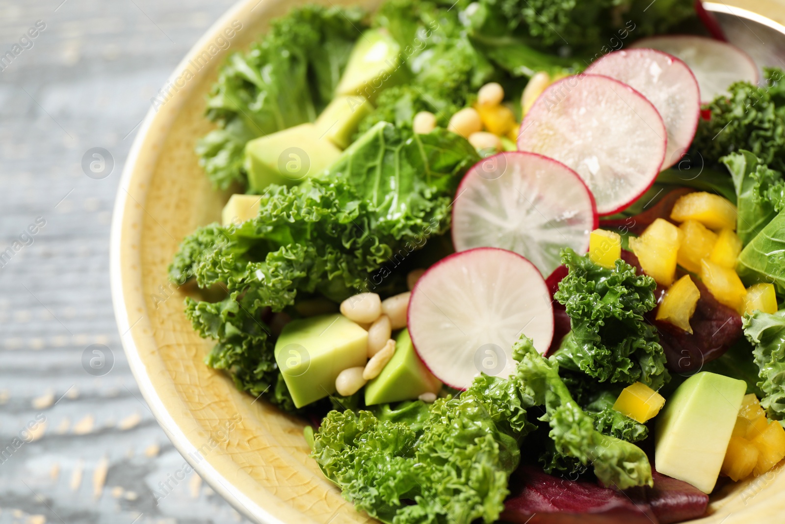 Photo of Delicious fresh kale salad in bowl, closeup