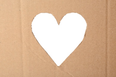 Photo of Heart shaped hole in cardboard on white background. Eco friendly material