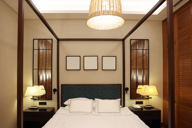 Photo of Large bed, lamps and pictures in comfortable hotel room