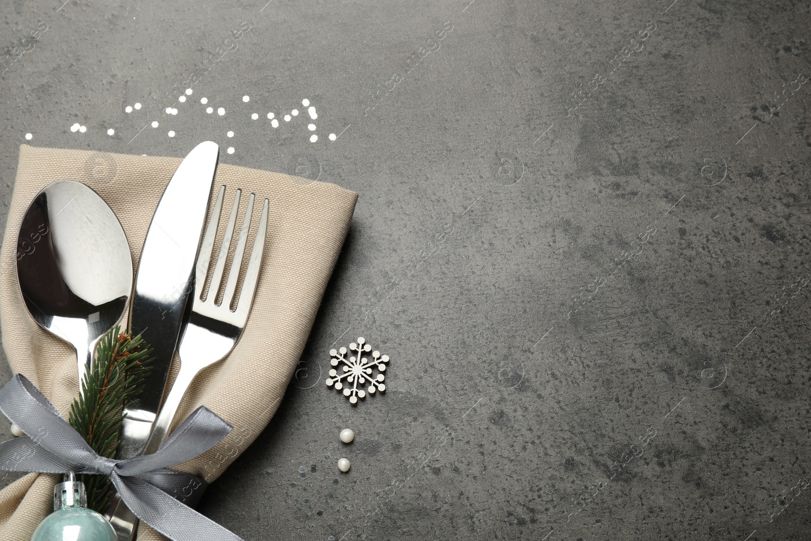 Photo of Cutlery set and festive decor on grey table, flat lay with space for text. Christmas celebration