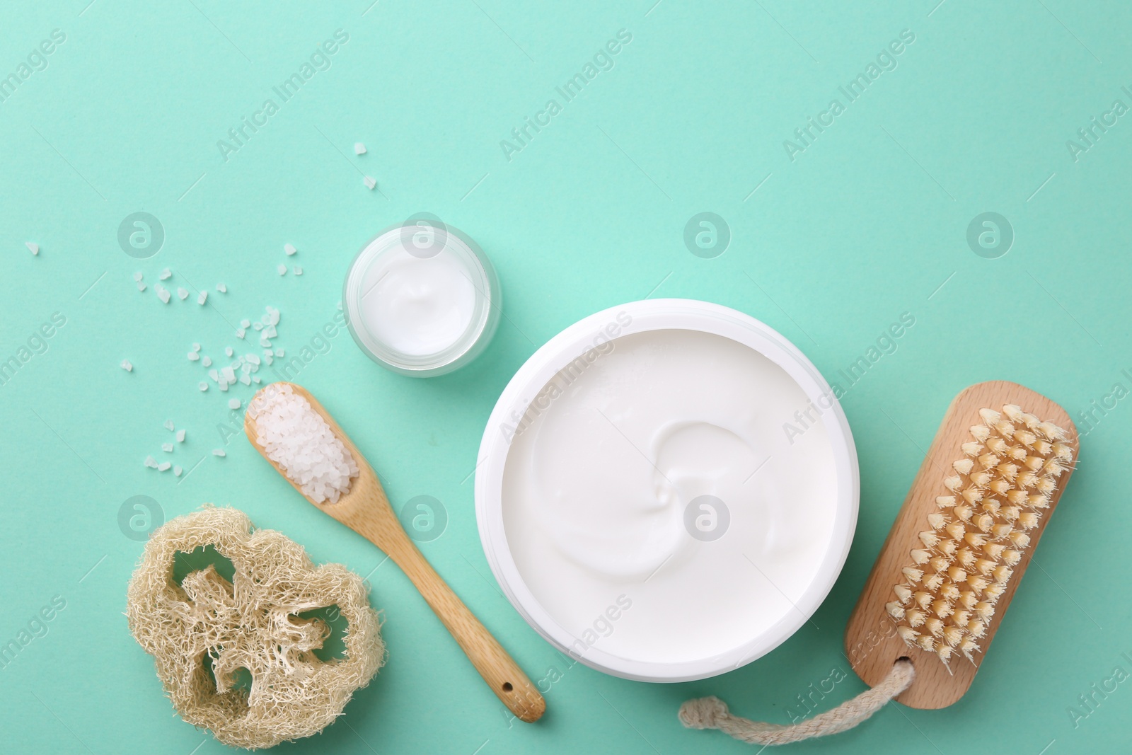 Photo of Jars of cream and body care products on turquoise background, flat lay. Space for text