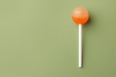 Photo of Tasty lollipop on green background, top view. Space for text