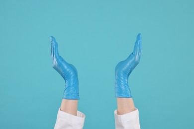 Doctor holding something on light blue background, closeup