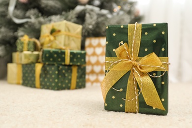 Photo of Beautiful Christmas gift and blurred pile of presents on background. Space for text