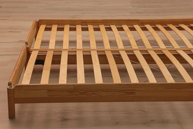 Photo of Wooden bed frame on floor, closeup view