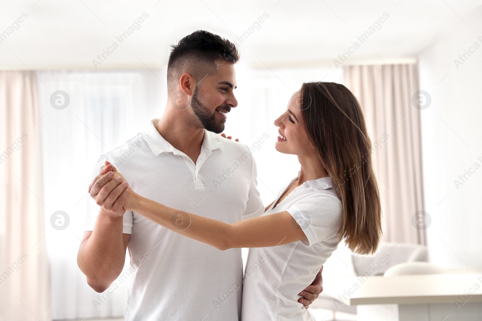 Photo of Lovely young couple dancing together at home