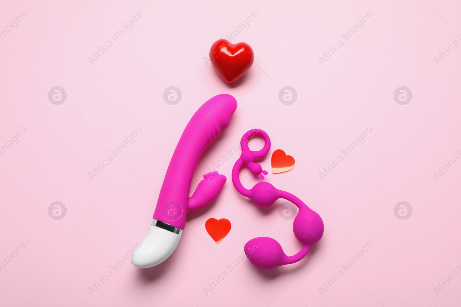 Photo of Flat lay composition with sex toys on pink background