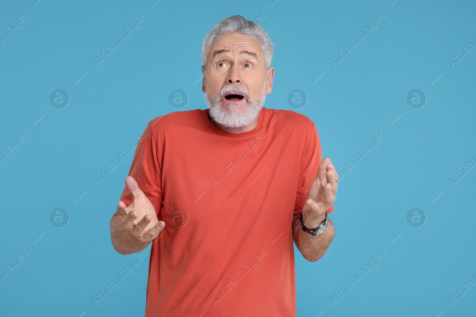 Photo of Portrait of surprised senior man on light blue background