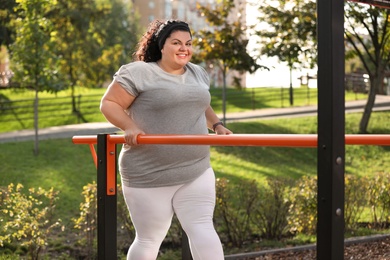 Photo of Beautiful overweight woman training on sports ground