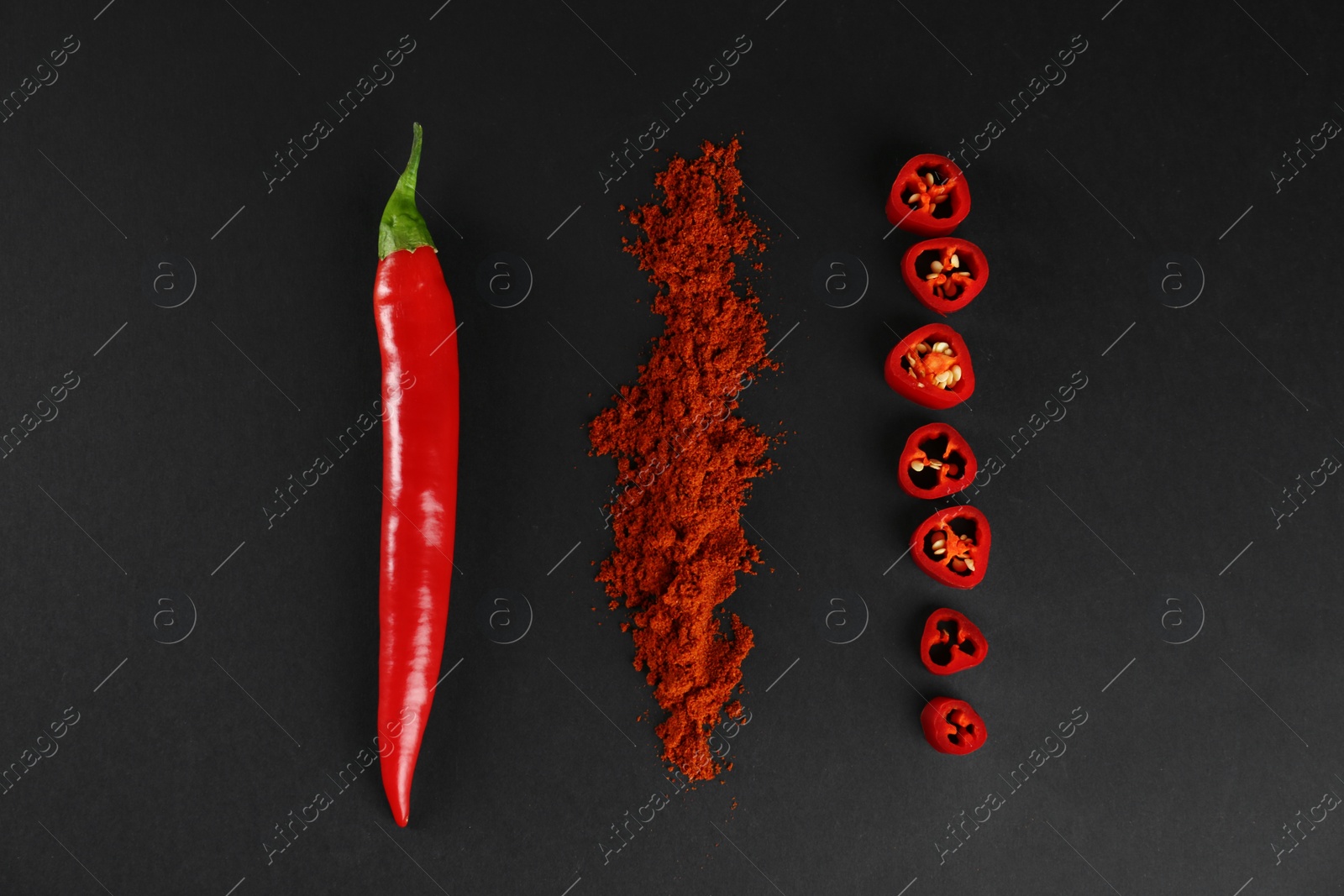 Photo of Ground red pepper and ingredient on black background, flat lay