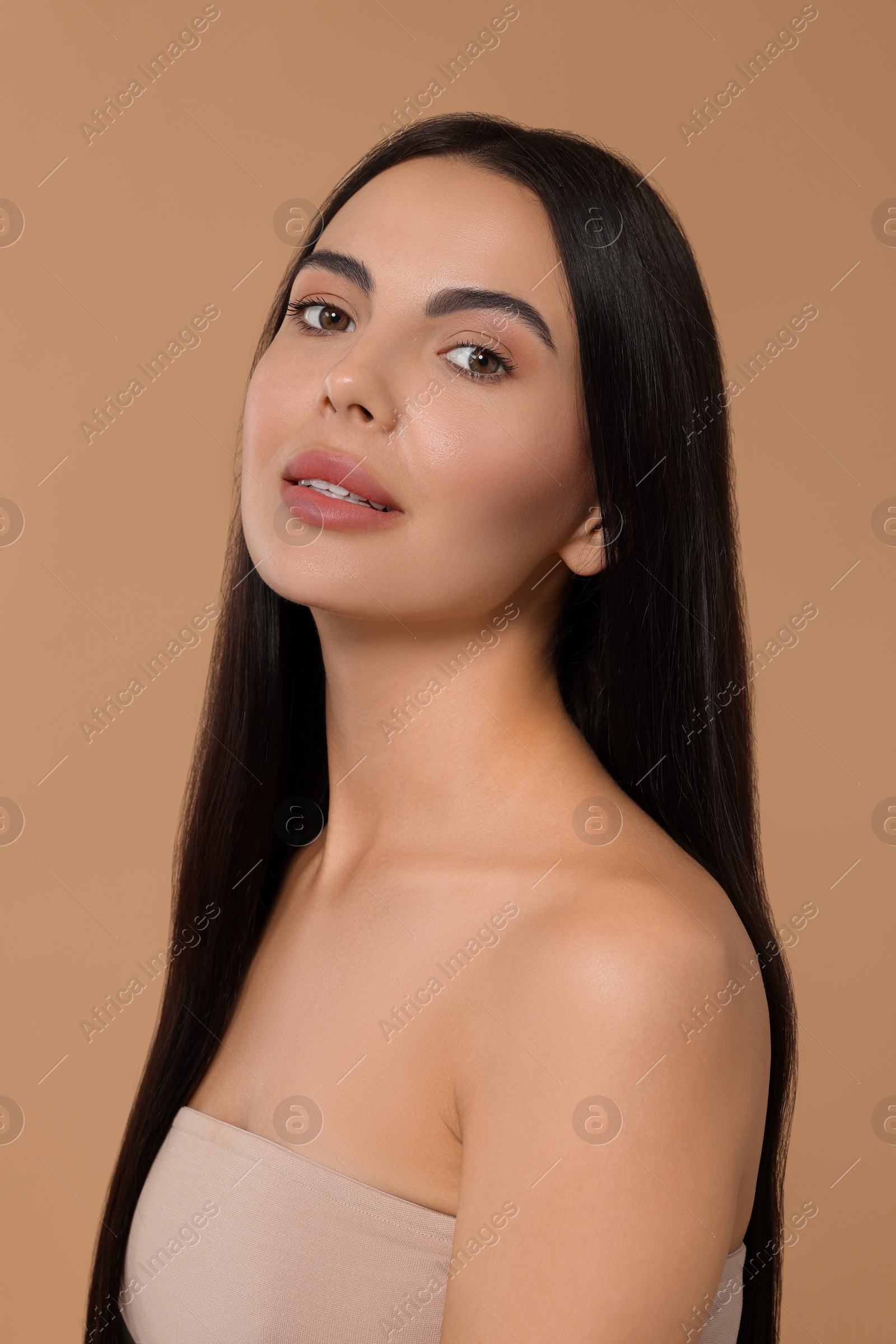 Photo of Beautiful woman with long hair on beige background