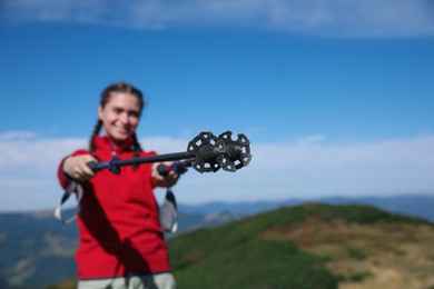 Photo of Hiker with trekking poles in mountains, focus on tips