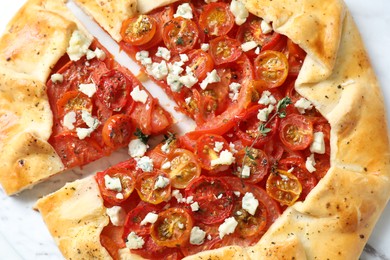 Tasty galette with tomato, thyme and cheese (Caprese galette) on white table, top view