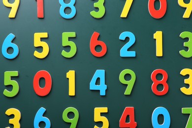 Colorful numbers on green background, flat lay